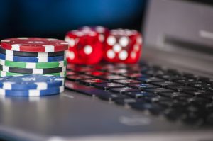 16970483-gambling-chips-and-red-dice-on-laptop-keyboard-background
